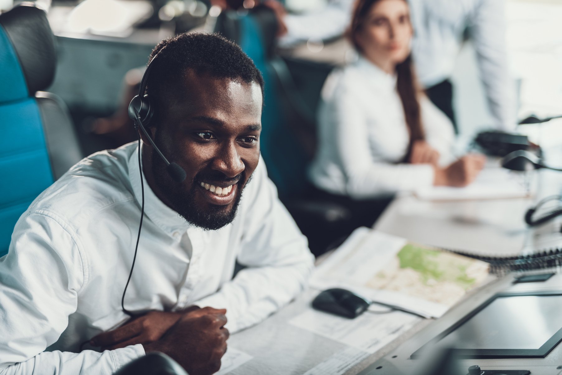 Smiling male dispatcher monitoring of flight data